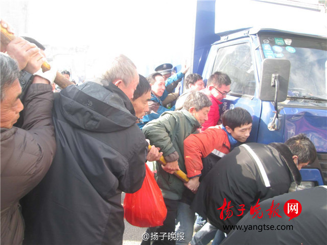 女子骑车遇车祸被压车下 众人抬车施救