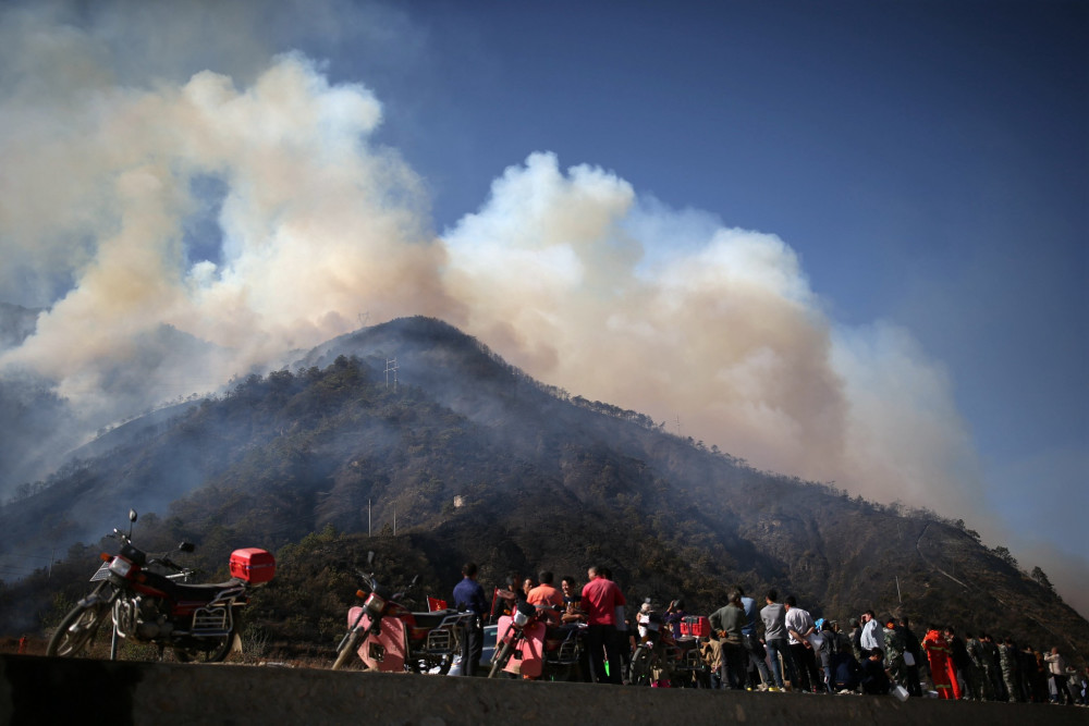 村民上坟引山火 直升机浓烟中紧急灭火