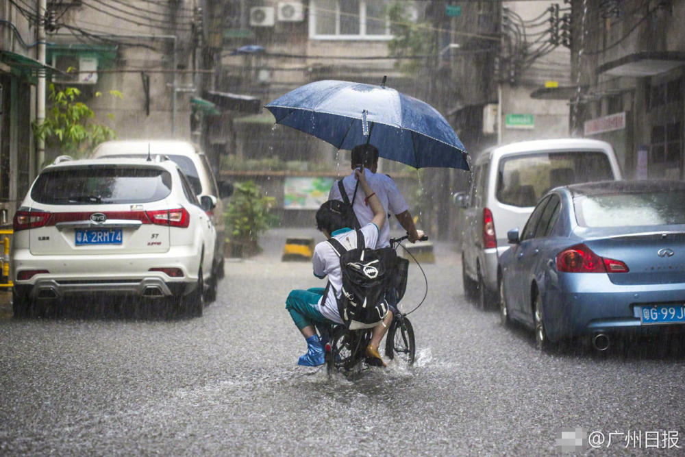 广州暴雨来袭道路积水 市民冒雨“踏浪”出行
