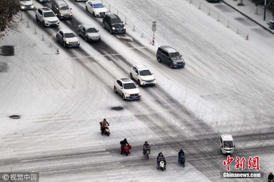 河南许昌迎来降雪天气 市民冒雪前行