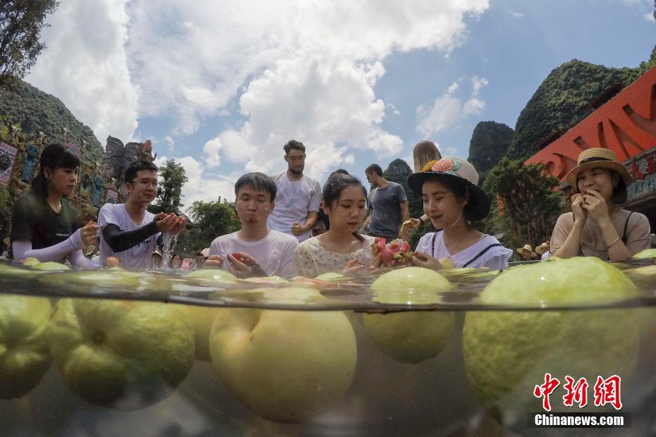 酷暑难耐 游人巨型冰桶内吃水果消暑